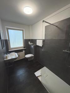 a bathroom with a toilet and a sink and a shower at Hotel Haus Hubertus in Schneverdingen +63 photos
