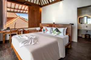 a bedroom with a large white bed with a table at Dream Nest Bali in Munggu +54 photos