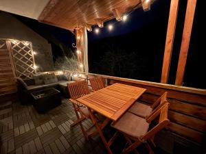 a wooden table and chairs on a deck at night at Ferienwohnung Tannenhöh in Todtmoos