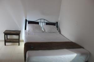 a bedroom with a bed and a nightstand next to it at Finca Campestre el Paraíso Resort Hotel en Mesitas in El Colegio +9 photos