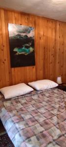 a bedroom with a bed with a painting on the wall at ApartmanMN in Žabljak