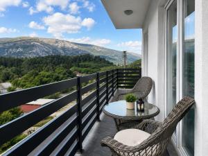 a balcony with a table and chairs and a view at Bonita Apartments in Mostar