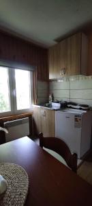 a kitchen with a table and a stove top oven at ApartmanMN in Žabljak
