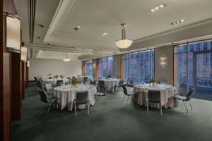 a banquet hall with white tables and chairs and windows at The Westin Melbourne in Melbourne