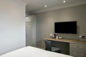 a bedroom with a desk with a television on the wall at Four Points Flex by Sheraton Nottingham in Nottingham