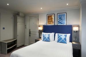 a bedroom with a large bed with blue and white pillows at Four Points Flex by Sheraton Nottingham in Nottingham +7 photos