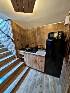 a kitchen with a black refrigerator and a sink at Podziemne Arkady-nocleg centrum blisko dworca in Gniezno