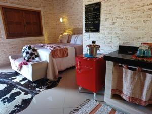a hotel room with a bed and a red refrigerator at Chalés Maktub 1 in Camanducaia
