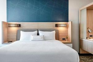 a bedroom with a large bed with a blue wall at SpringHill Suites by Marriott Appleton in Appleton +41 photos