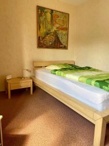 a bedroom with a bed and a painting on the wall at B&B Pension-Schönheim in Monzingen