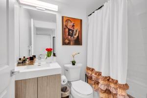 a bathroom with a toilet and a shower curtain at Filmos Hotel and Suites in Toronto +98 photos