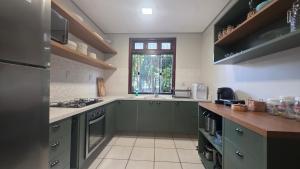 a kitchen with green cabinets and a window at Alter Beach in Alter do Chao +14 photos