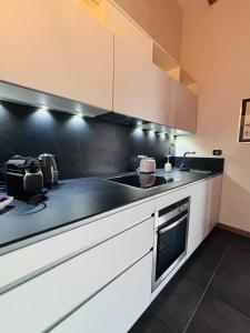 a kitchen with white cabinets and a black counter top at Lazise Suite in Lazise +12 photos