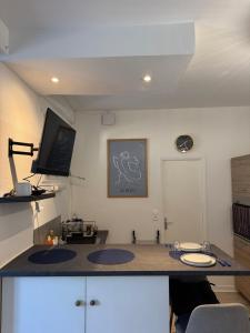 a room with a desk with two sinks and a tv at Le Nid Malouin in Saint Malo