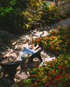 two women sitting on a bench in a garden at Hotel Bo in San Cristóbal de Las Casas