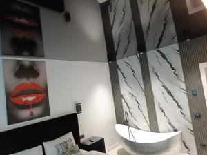a bedroom with a bed and a bathroom with a mirror at HERA Elysium Apartament EROS in Sinaia