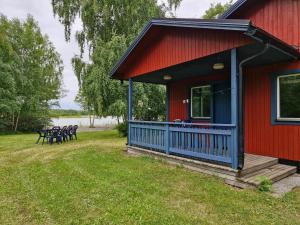 ein rotes Haus mit einer Terrasse mit Tischen und Stühlen in der Unterkunft Utkiken in Eckerö + 8 Fotos