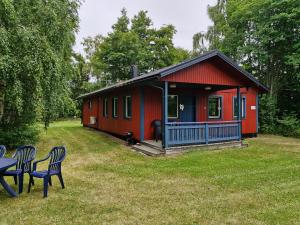 eine rote Hütte mit zwei Stühlen davor in der Unterkunft Utkiken in Eckerö