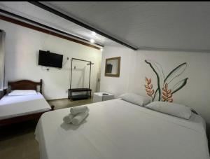 a bedroom with a large white bed and a television at Pousada e Chocolateria Muito Mais in Itaparica +12 photos