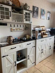 a kitchen with white cabinets and black counter tops at B&B Pension-Schönheim in Monzingen