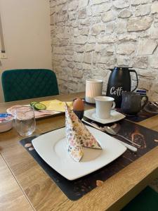 a table with a plate with a slice of pizza on it at B&B Pension-Schönheim in Monzingen