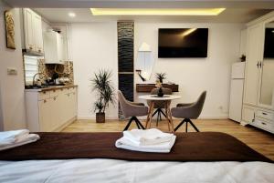 a bedroom with a bed with a table and chairs at Verso Studio in Curtea de Argeş