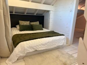 a bedroom with a large bed with green pillows at Au P'ti Chalet in Souvans