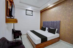 a bedroom with a bed and a chair at Hotel O Rooftop Inn in New Delhi