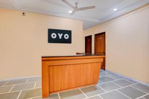 a court desk in a room with a sign on the wall at SPOT ON Hotel Silver Spoon in Dhule +23 photos
