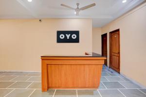 a desk in a room with a sign on the wall at SPOT ON Hotel Silver Spoon in Dhule