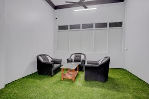 two chairs and a table in a room with grass at SPOT ON Hotel Silver Spoon in Dhule
