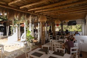 a group of people sitting at tables in a restaurant at Hotel Natali 2 in Dhërmi