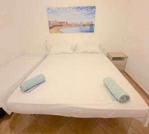 a large white bed with two towels on it at Cuttin Apartment in Gallipoli