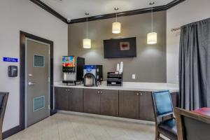 a waiting room with a counter and a chair at Humble Inn & Suites in Humble