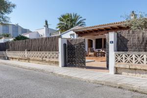 a house with a gate on the side of a street at Chalet Falcó with Private Pool and Garden in Port d'Alcudia