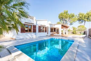 a swimming pool in front of a house at Chalet Falcó with Private Pool and Garden in Port d'Alcudia
