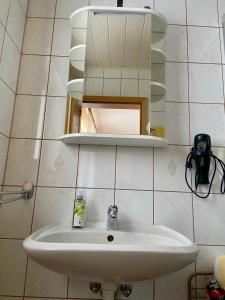 a bathroom with a sink and a mirror at B&B Pension-Schönheim in Monzingen