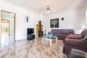 a living room with a couch and a tv at Chalet Falcó with Private Pool and Garden in Port d'Alcudia