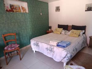 a bedroom with a bed and a chair in it at Chez Annick in Escoeuilles