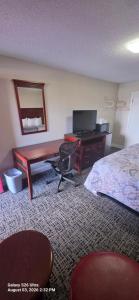 a hotel room with a desk and a bed at Red Carpet Inn Williamstown in Williamstown +18 photos
