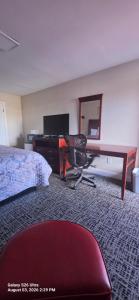 a hotel room with a desk and a bed at Red Carpet Inn Williamstown in Williamstown