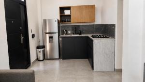 a small kitchen with a stainless steel refrigerator at Loft privado con alberca - Cama King in El Centenario