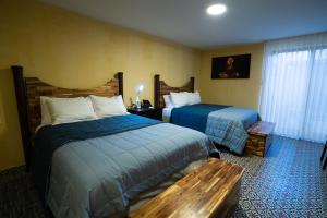 a hotel room with two beds and a bench at Kali Doña Tere in Acámbaro