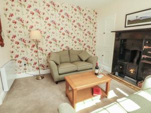 a living room with a couch and a fireplace at East View in Kirkby Stephen