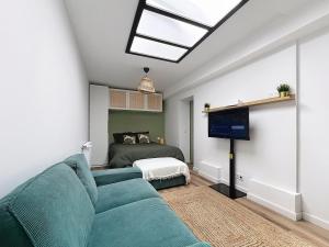 a living room with a couch and a bed at Le Cosy Garibaldi in Sotteville-lès-Rouen