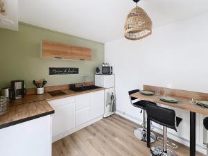 a kitchen with white cabinets and a counter top at Le Cosy Garibaldi in Sotteville-lès-Rouen +5 photos