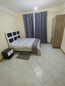 a bedroom with a bed and a tiled floor at Kilima Suites in Taveta