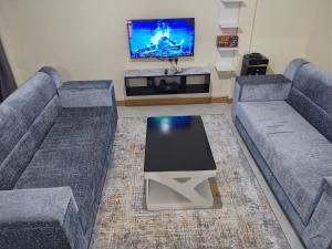 a living room with two couches and a tv at Kilima Suites in Taveta