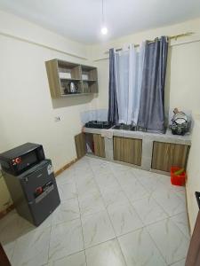 a room with a kitchen with a stove and a window at Kilima Suites in Taveta