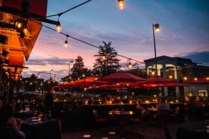 a restaurant with tables and umbrellas at night at Hôtel Alt Québec in Quebec City